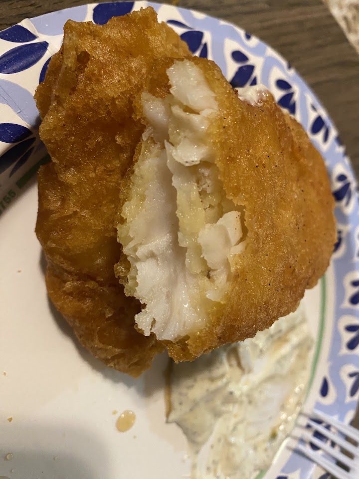 A fish fillet broken open to show flaky white fish